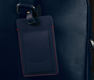 Navy Blue Leather Luggage Tag attached to luggage