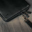 Black Leather Messenger Bag on a wooden table