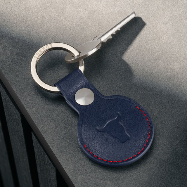 Navy Blue with Red Detail Leather Apple AirTag Holder Keyring attached to a key